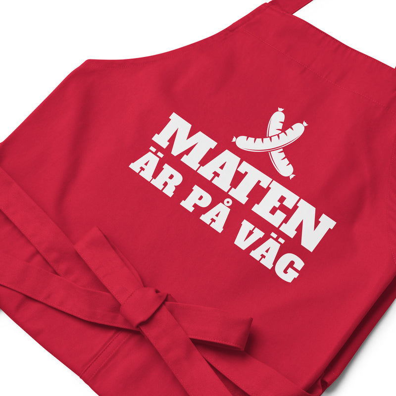 Förkläde med texten "Maten är på väg"